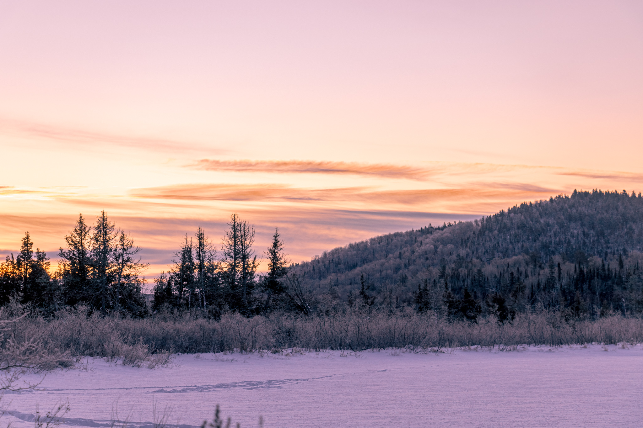 Hoarfoast on distant trees and hills in a pre-sunrise glow on the Gunflint Trail, near Grand Marais, MN
