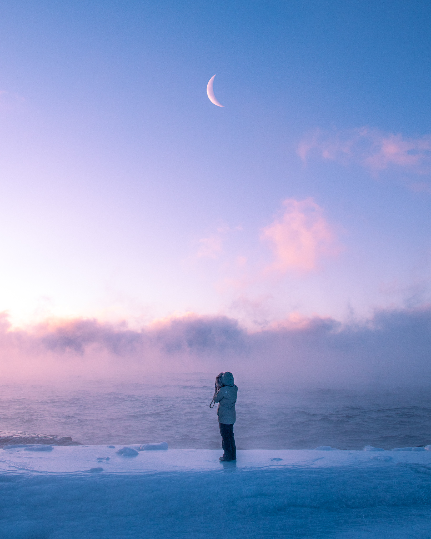 A photographer stands in sea smoke at Artist's Point, MN