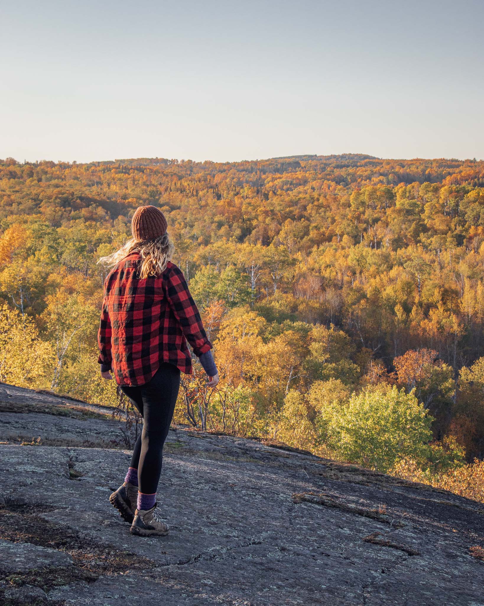 Hiker in plaid on the Pincushion Mountain Overlook in the Fall in Grand Marais Minnesota