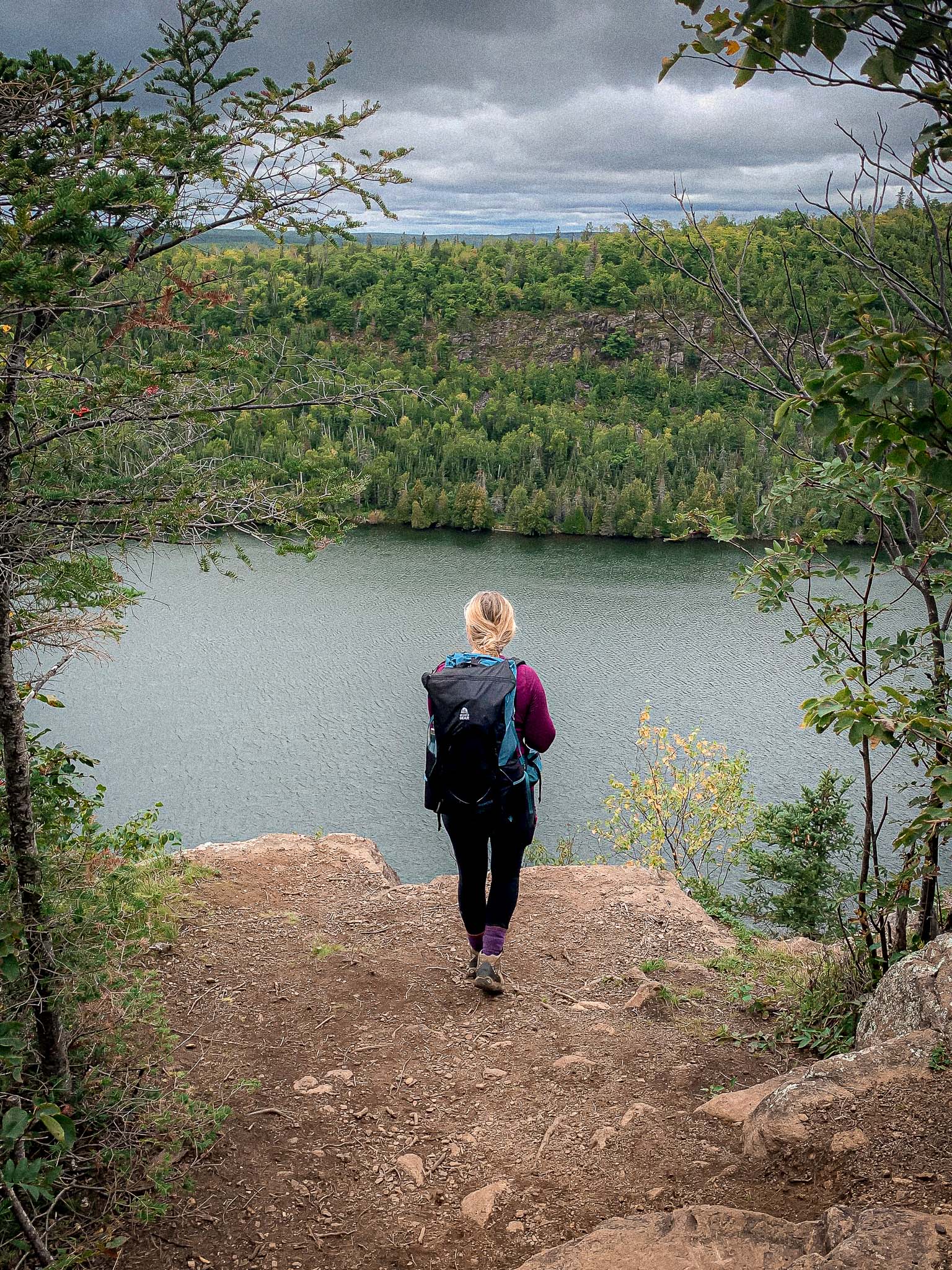 A hiker stands at the cliffs overlooking bean and bear lakes, a hiking trial on the north shore of Minnesota