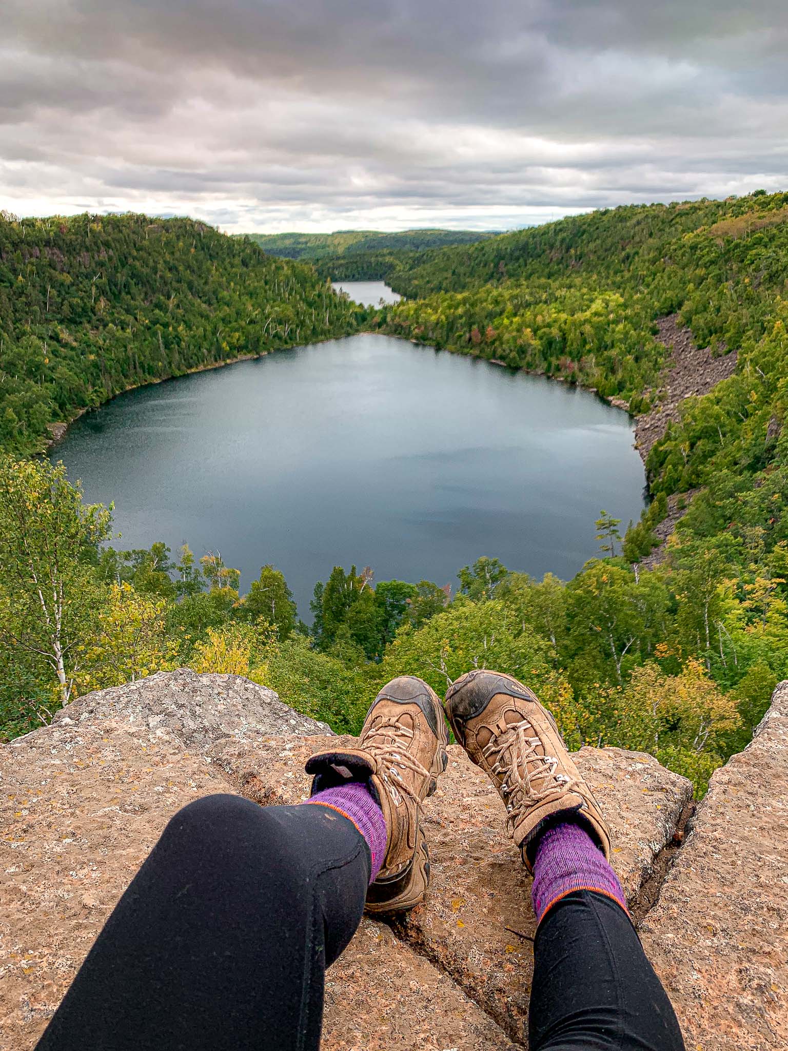 image of a hiker's legs with Bean and Bear lakes overlook in the background, rugged north shore of Minnesota
