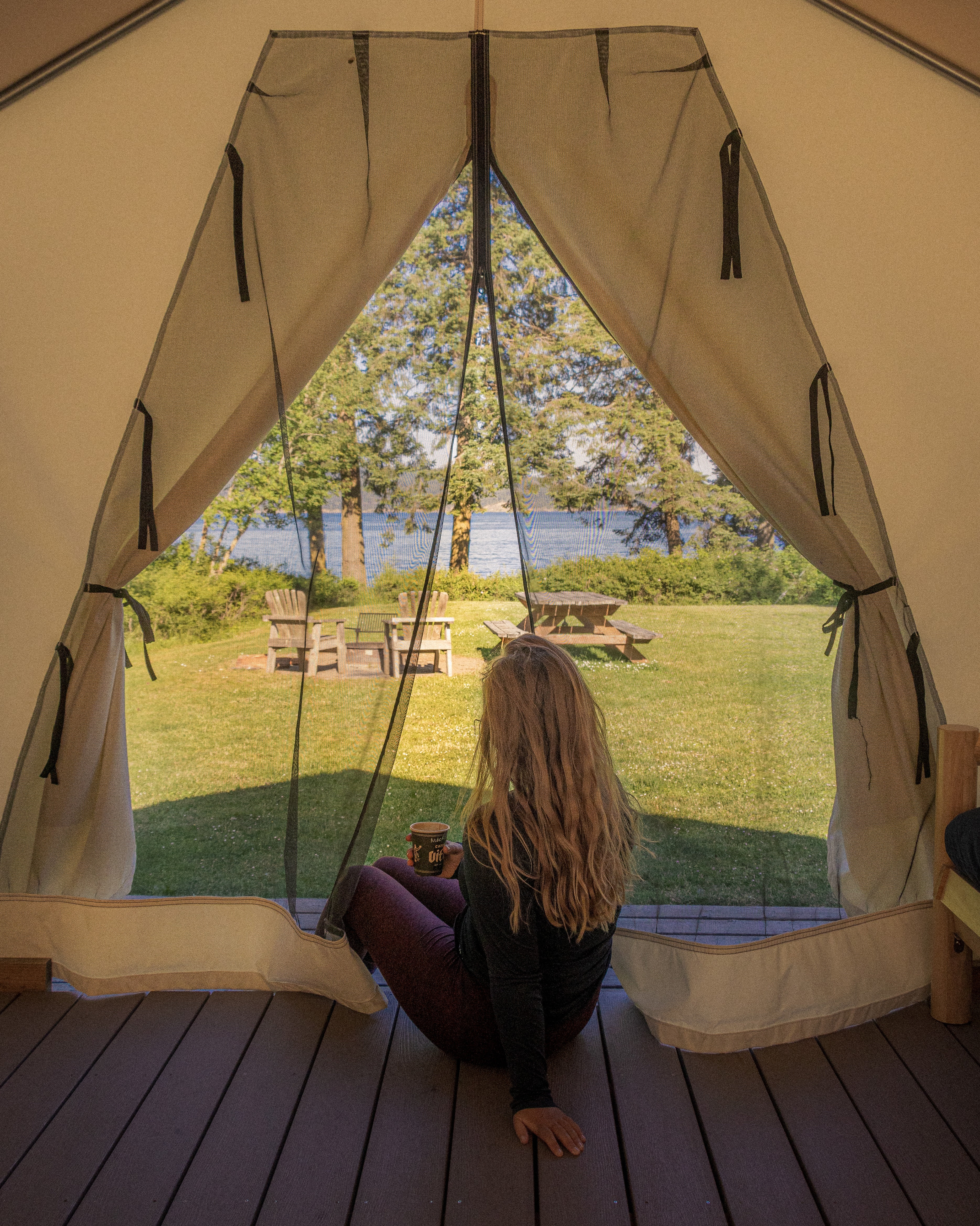image of a woman drinking coffee in a glamping tent on Orcas Island