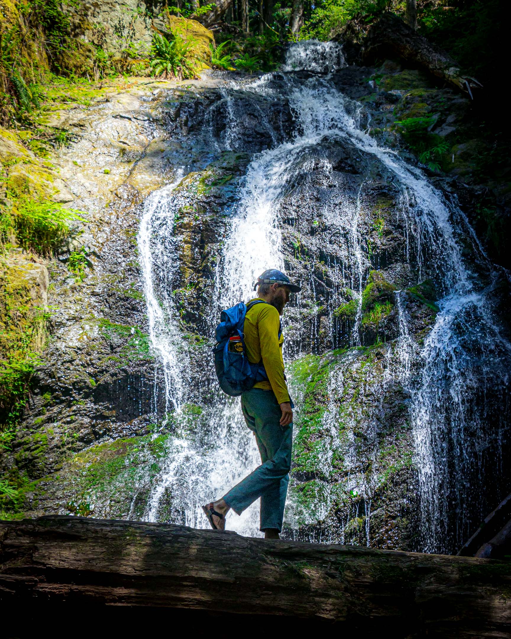 A hiker in front of Cascade Falls on Orcas Island, Washington