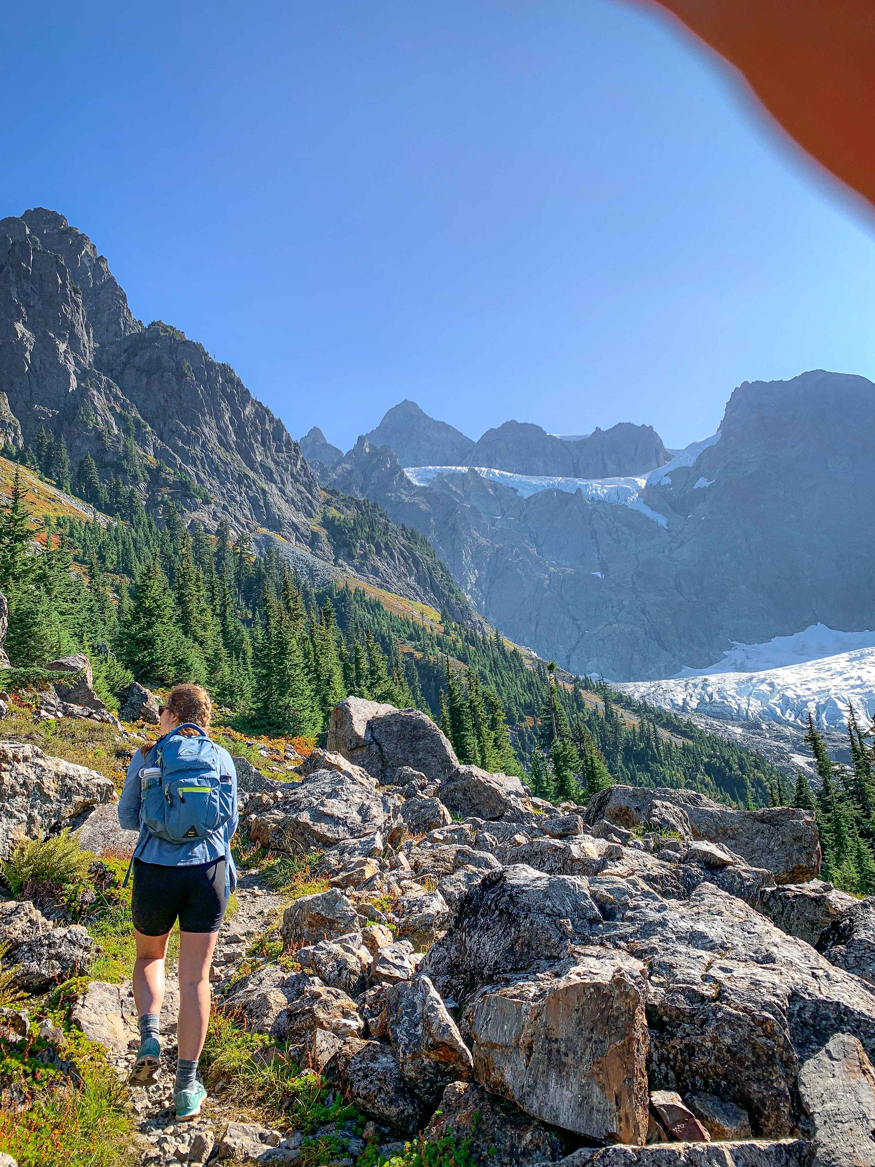 A day hiker in shorts, trail runners, and with a hiking backpack in the North Cascades