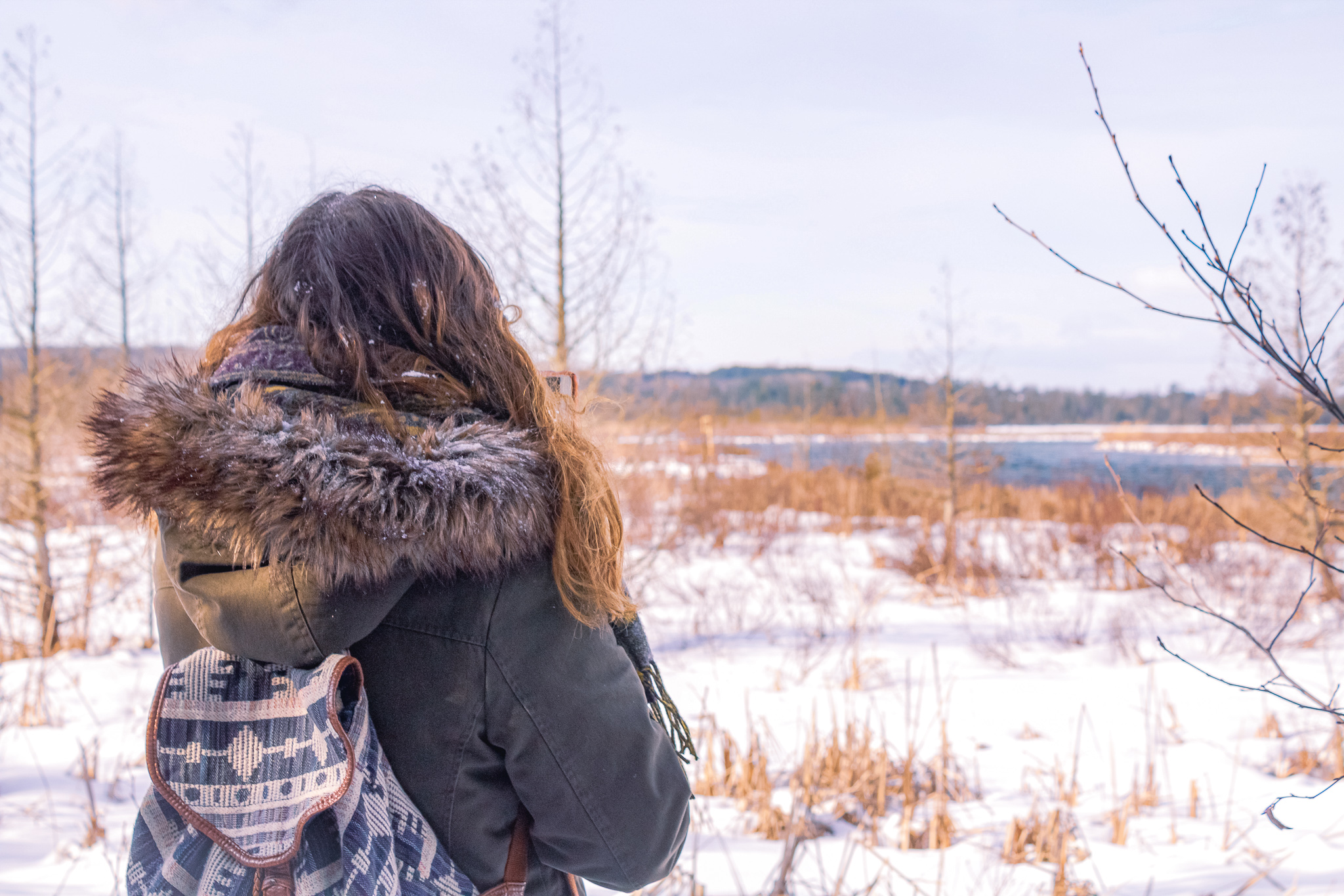 A hiker in front of a snowy scene in Northern Michigan 