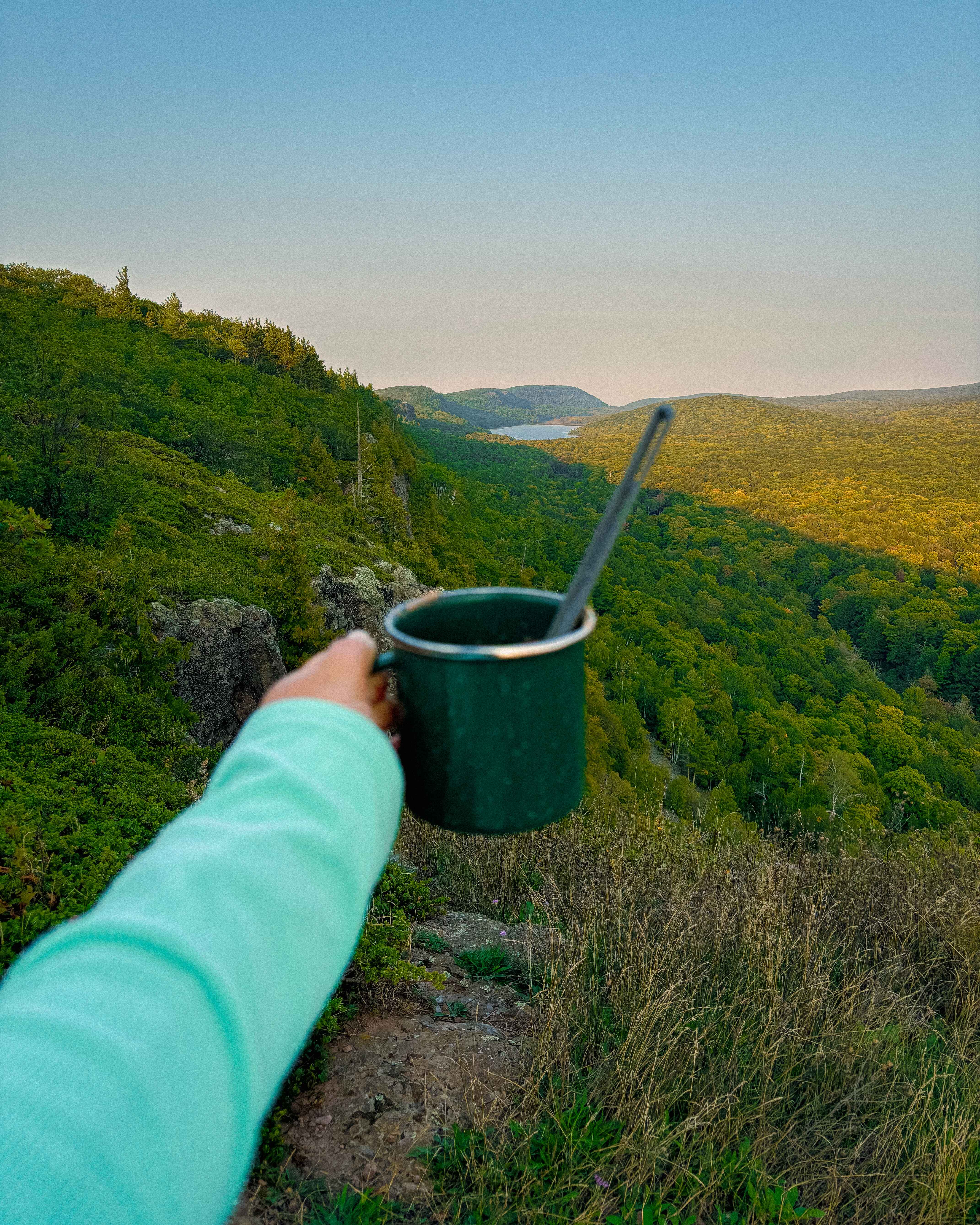 a cup of hot coco at sunset in porcupine mountains wilderness state park, michigan