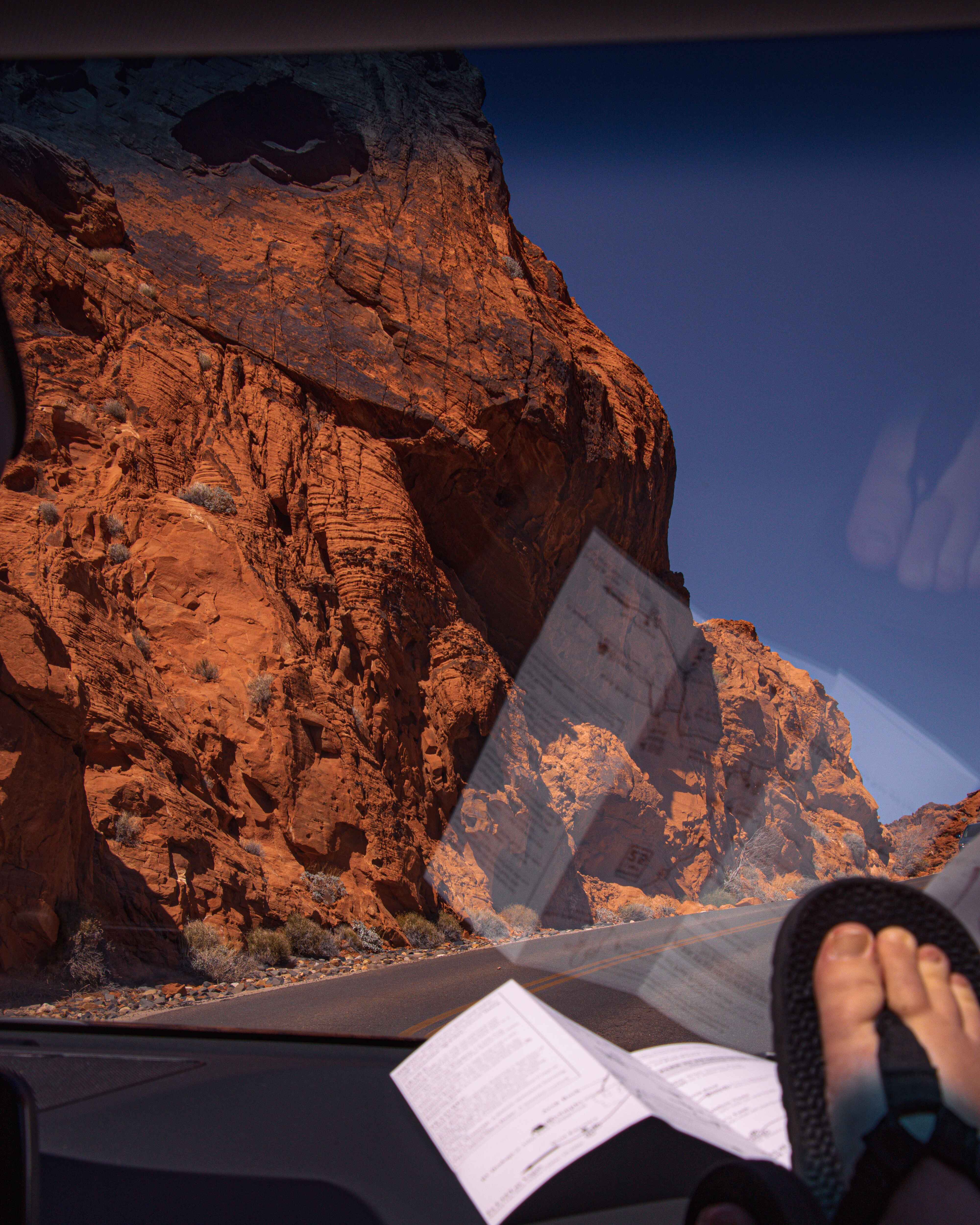 Driving through Valley of Fire State Park, a hiker rest there feet and bedrock sandals on the dash of a car