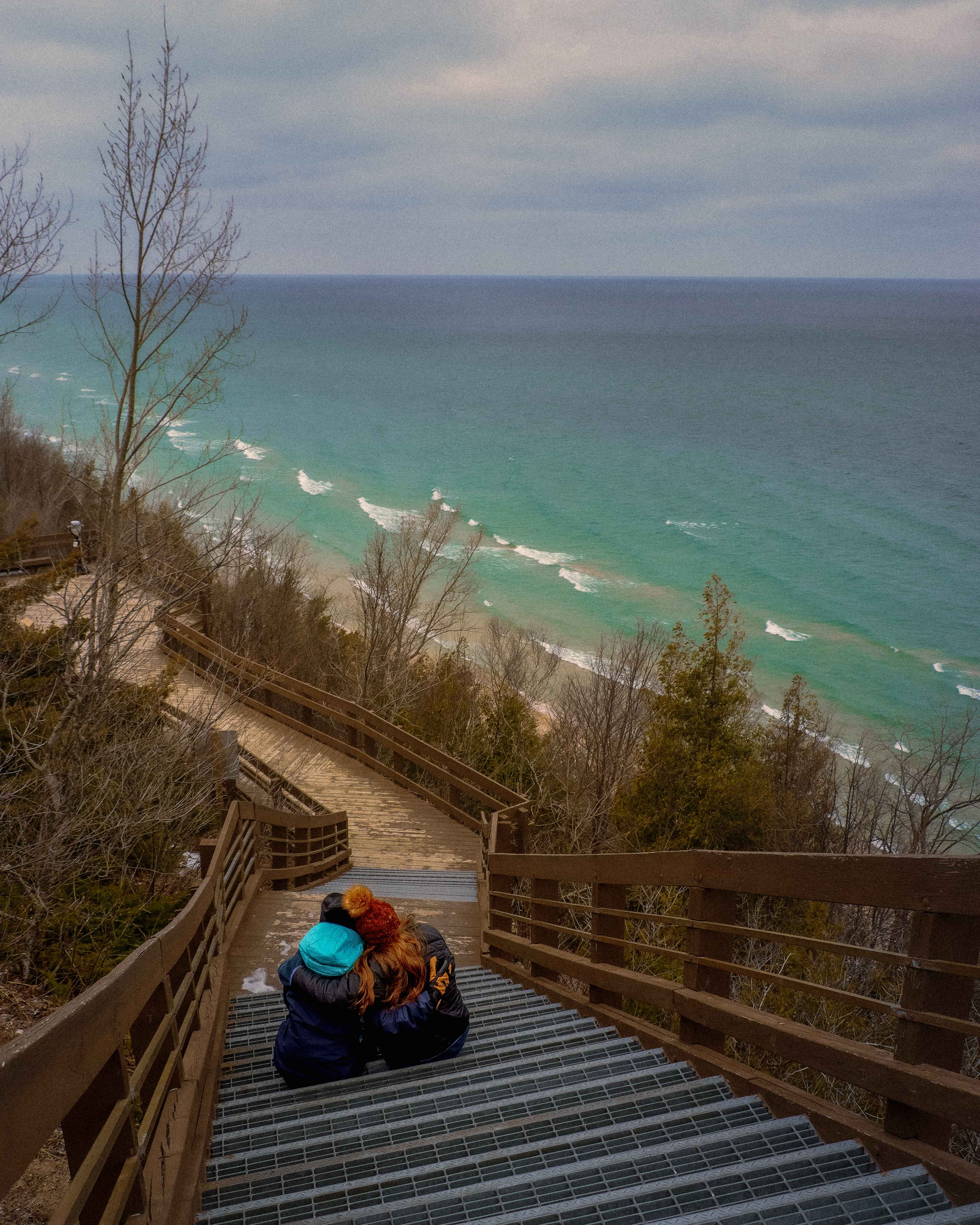 Hikers sit on a boardwalk over Lake michigan near Frankfort, Michigan