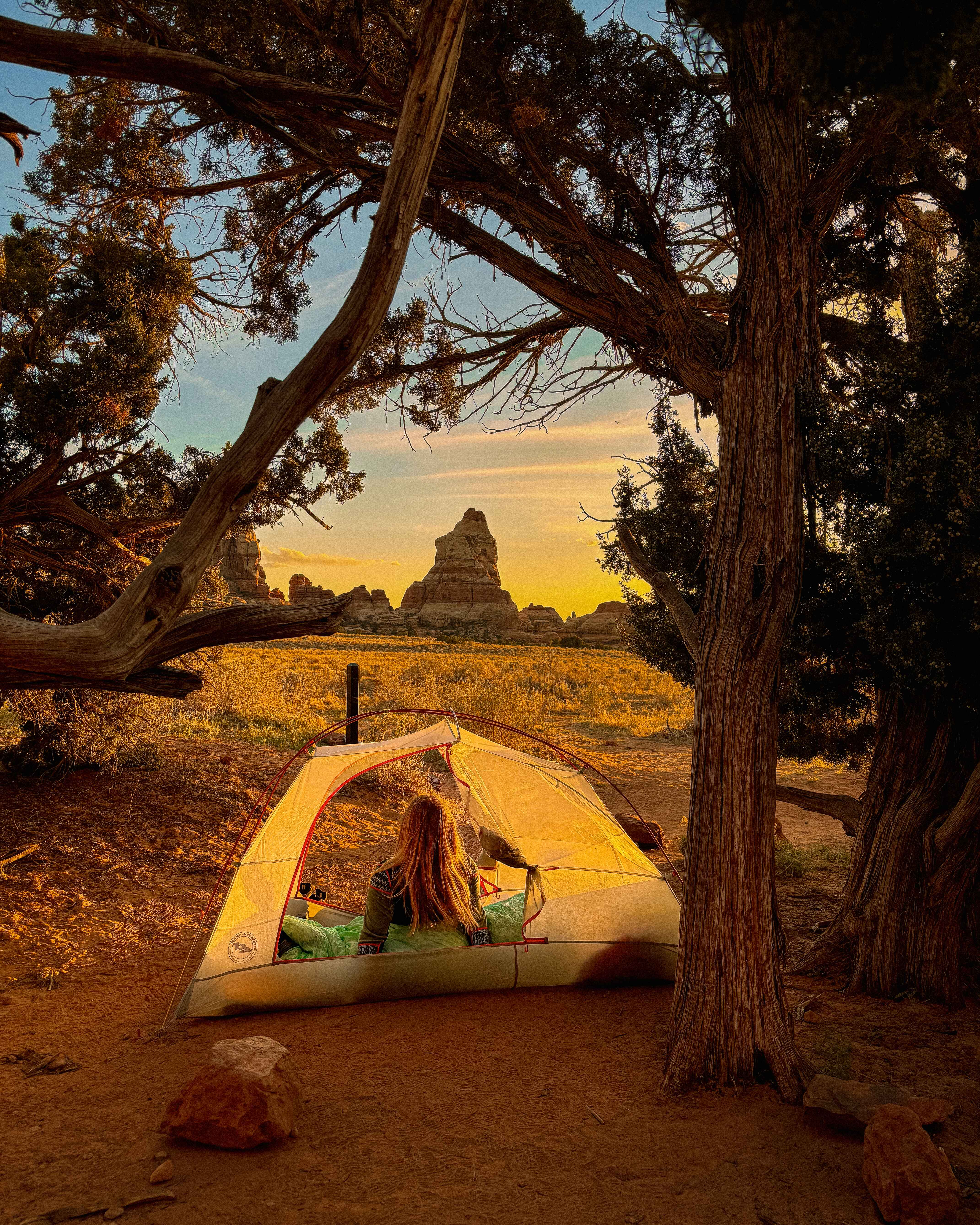 a hiker lounges in a tent in the needles district of canyonlands naitonal park, utah | a backpacker in the desert