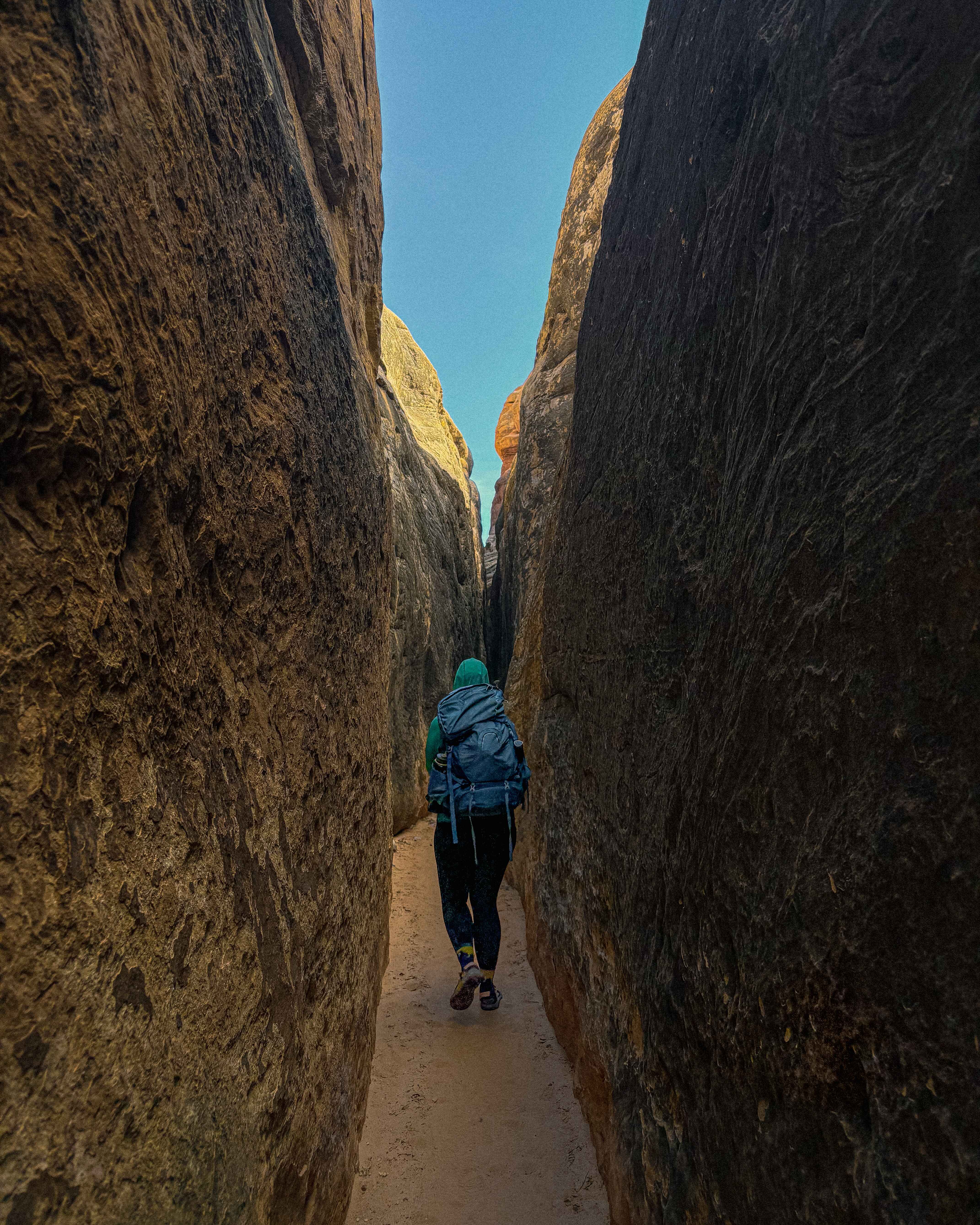 A hiker in a slot canyon on the Joint Trail in the Needles District of Canyonlands National Park, Utah