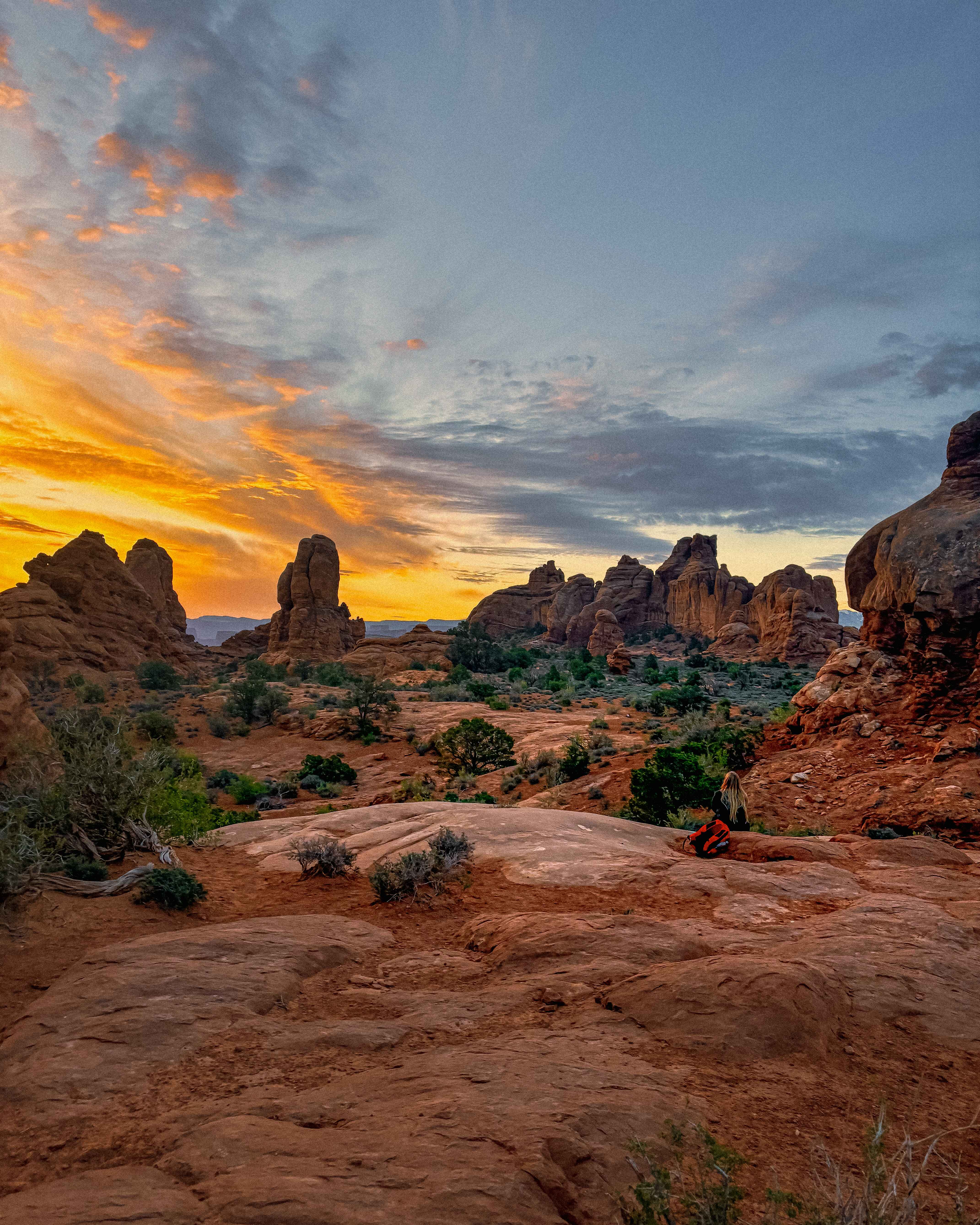 the sunrises over red rock desert in Arches National Park, near Moab Utah