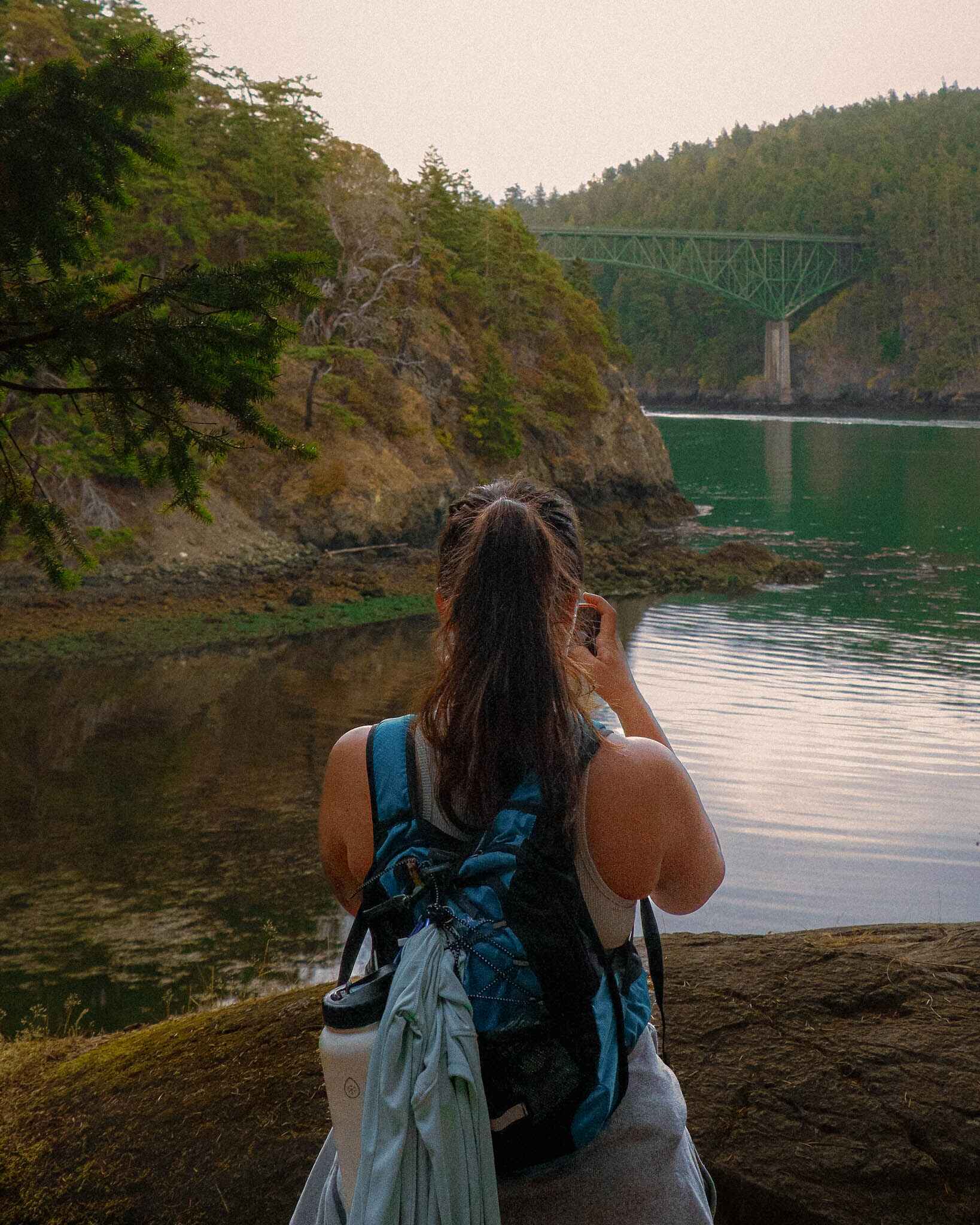 a hiker stands near the deception pass bridge