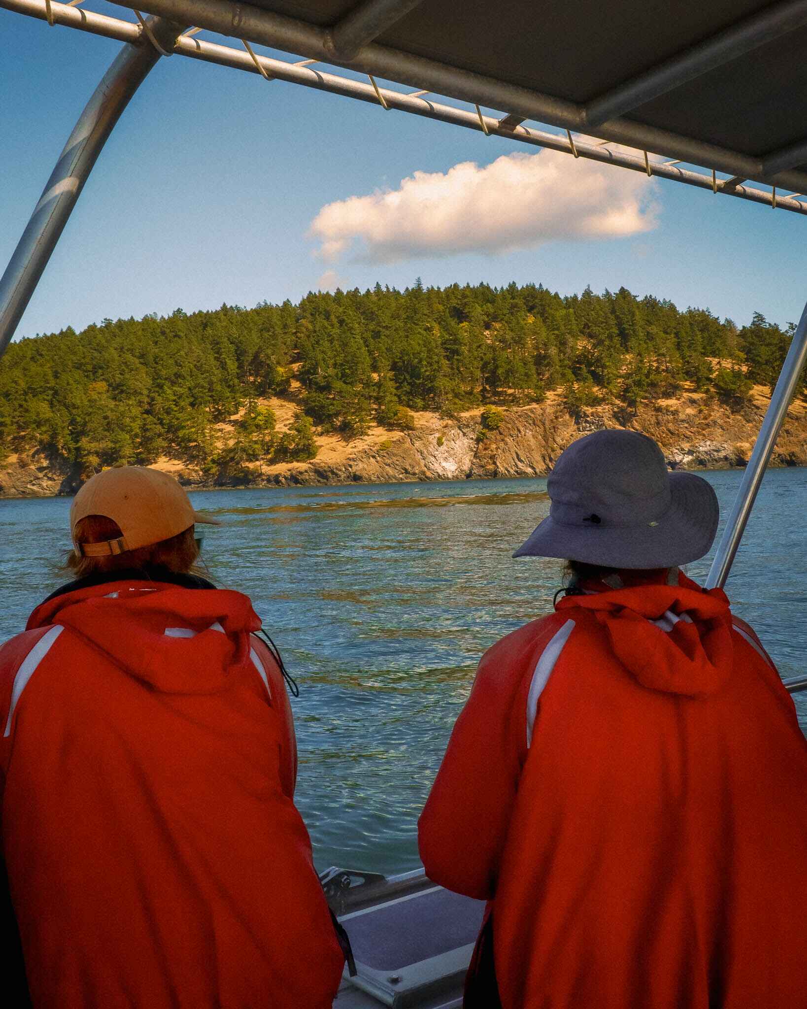 two women stand at the edge of a boat on a whale watching tour on san juan island