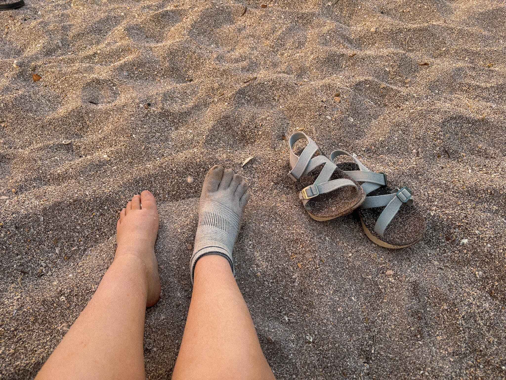 image of a hikers feet in the sand with women's tread labs redway adventure sandals