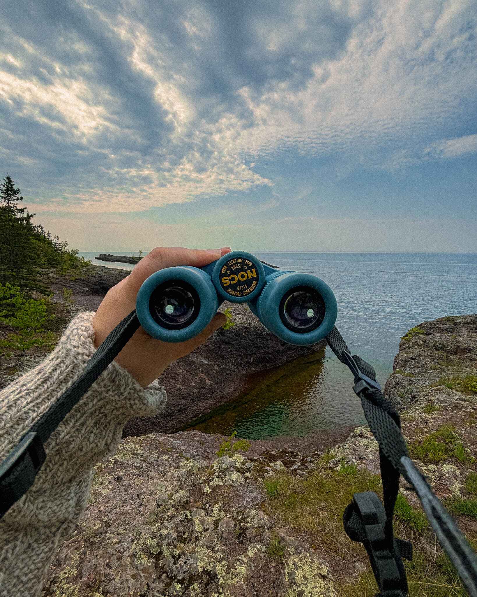 Image of binoculars on rugged lake superior shoreline near copper harbor michigan