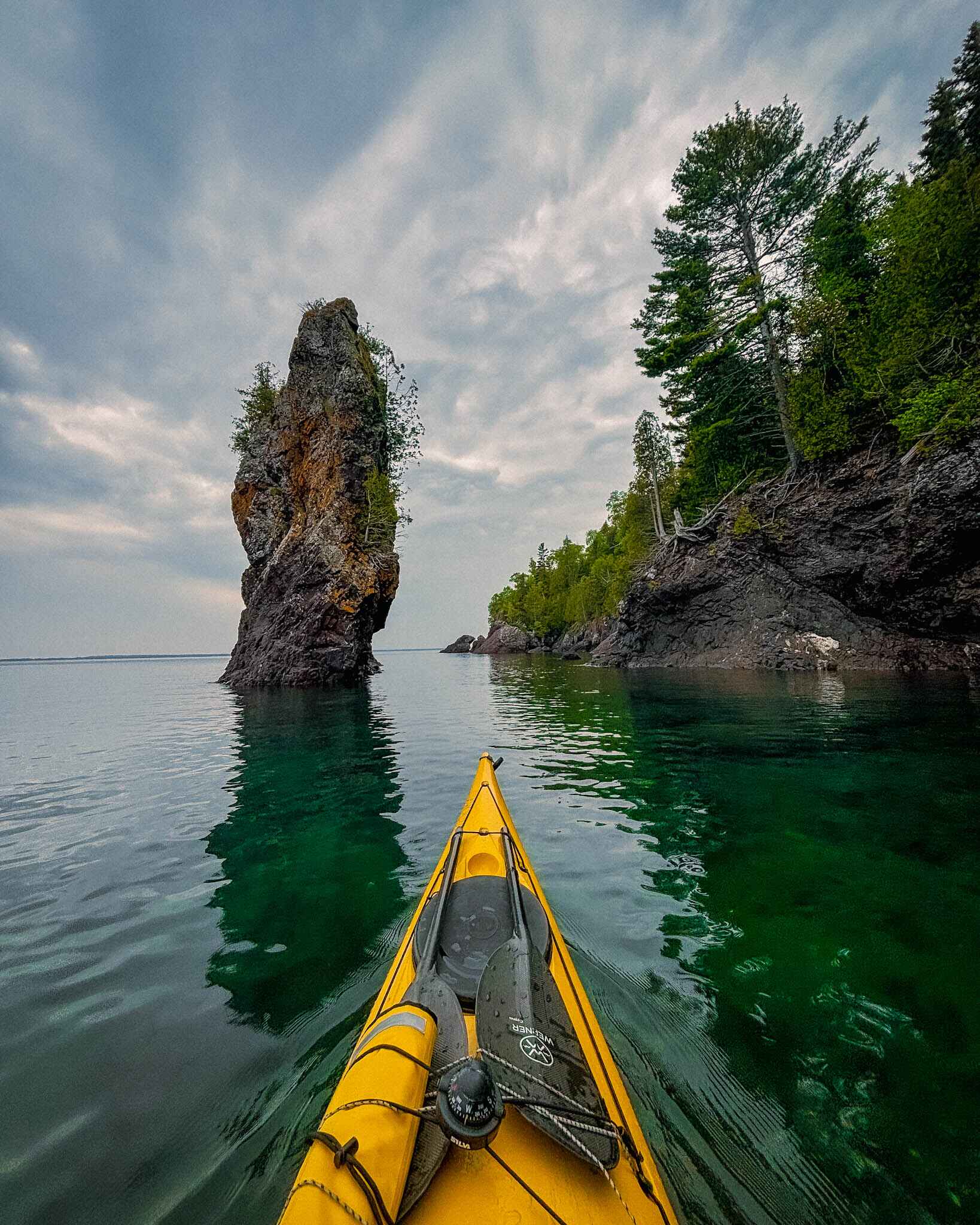 Image of kayaking toward a sea stack along the rugged shores of Michigan's Keweenaw Peninsula