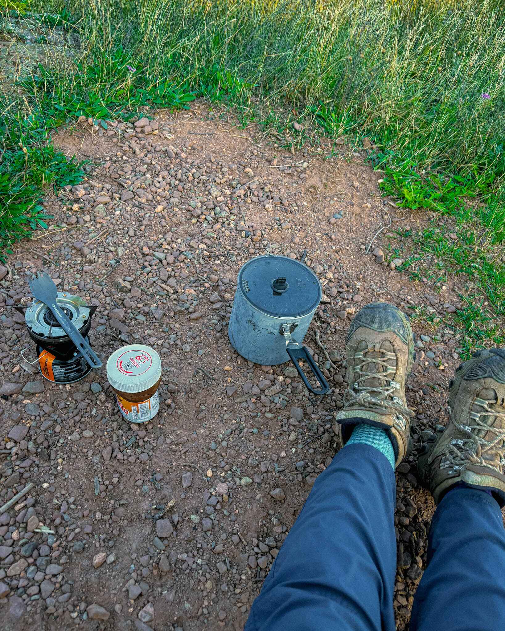 Image of a simple backpacker stove setup with a pot, spork, and nutella
