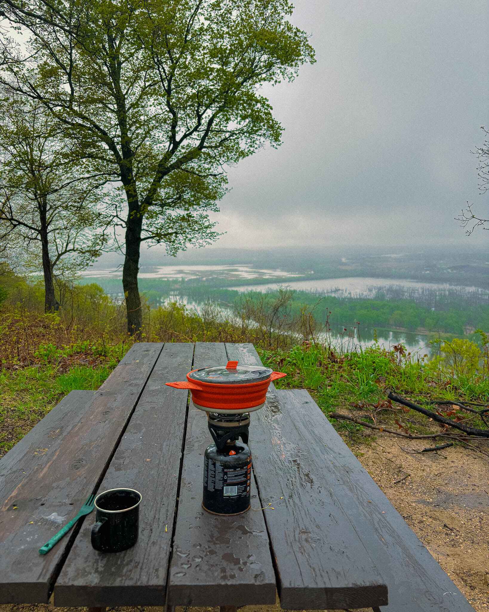 Jetboil camp stove with the pan attachment over view of a campsite on the Wisconsin River in Wyalusing State park