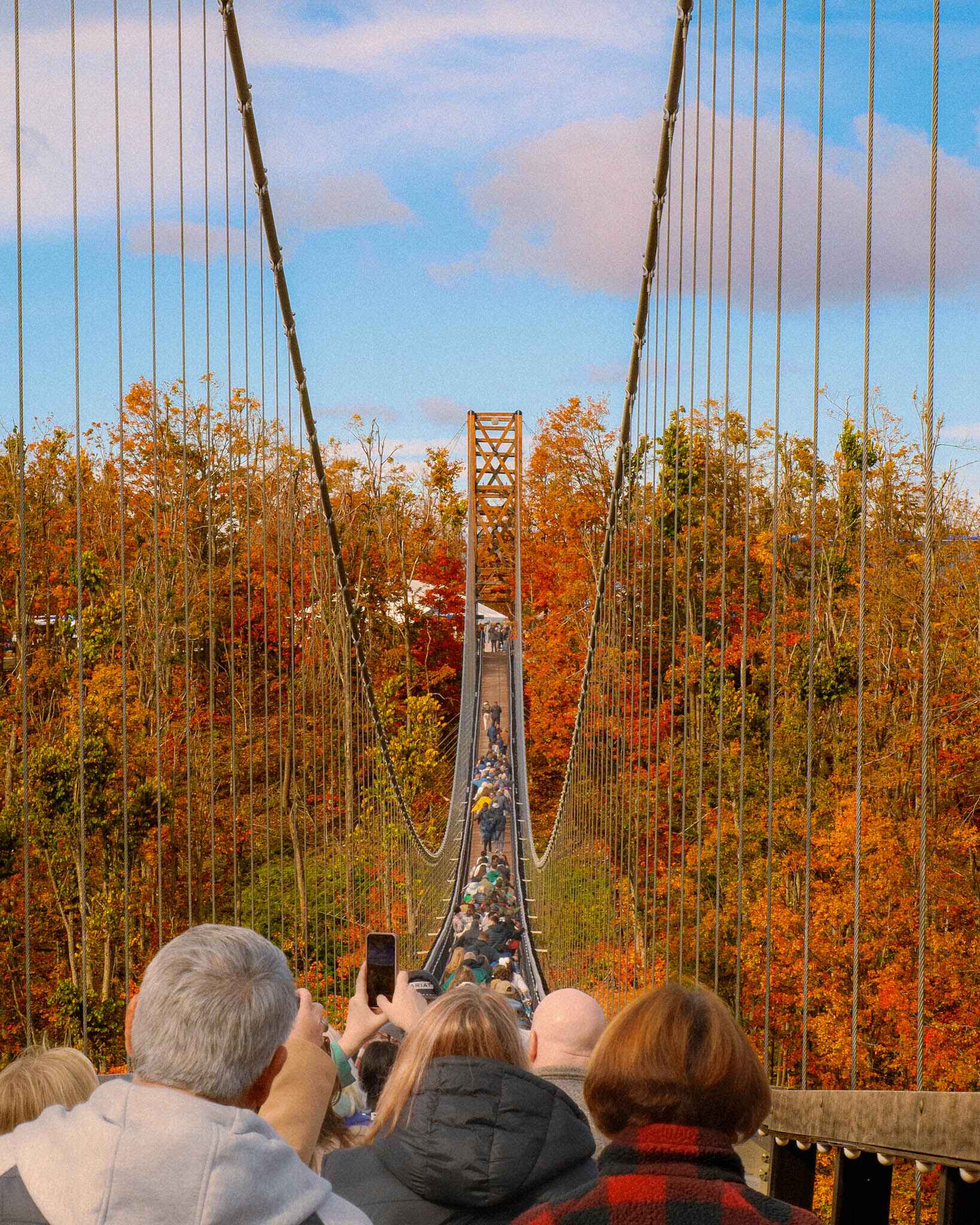 Travelers hike across the Boyne Mountain sky bridge near Traverse City michigan