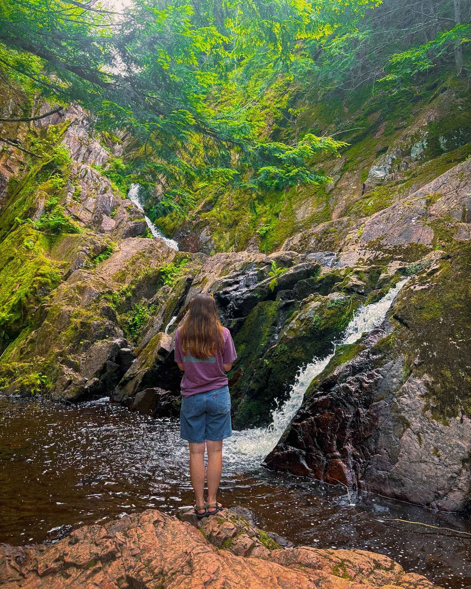 A Hiker stands in front of Morgan Falls in the Chequamegon Nicolet National Forest in Northern Wisconsin