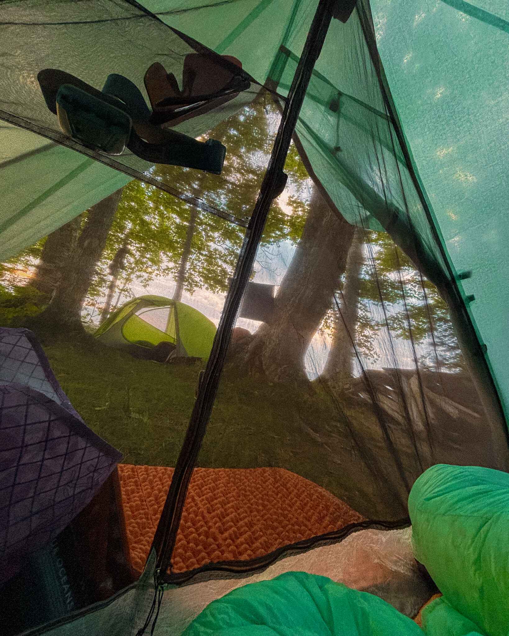 image looking out of a backpacking tent to a nemo switchback sleeping pad used as a door mat/sit pad