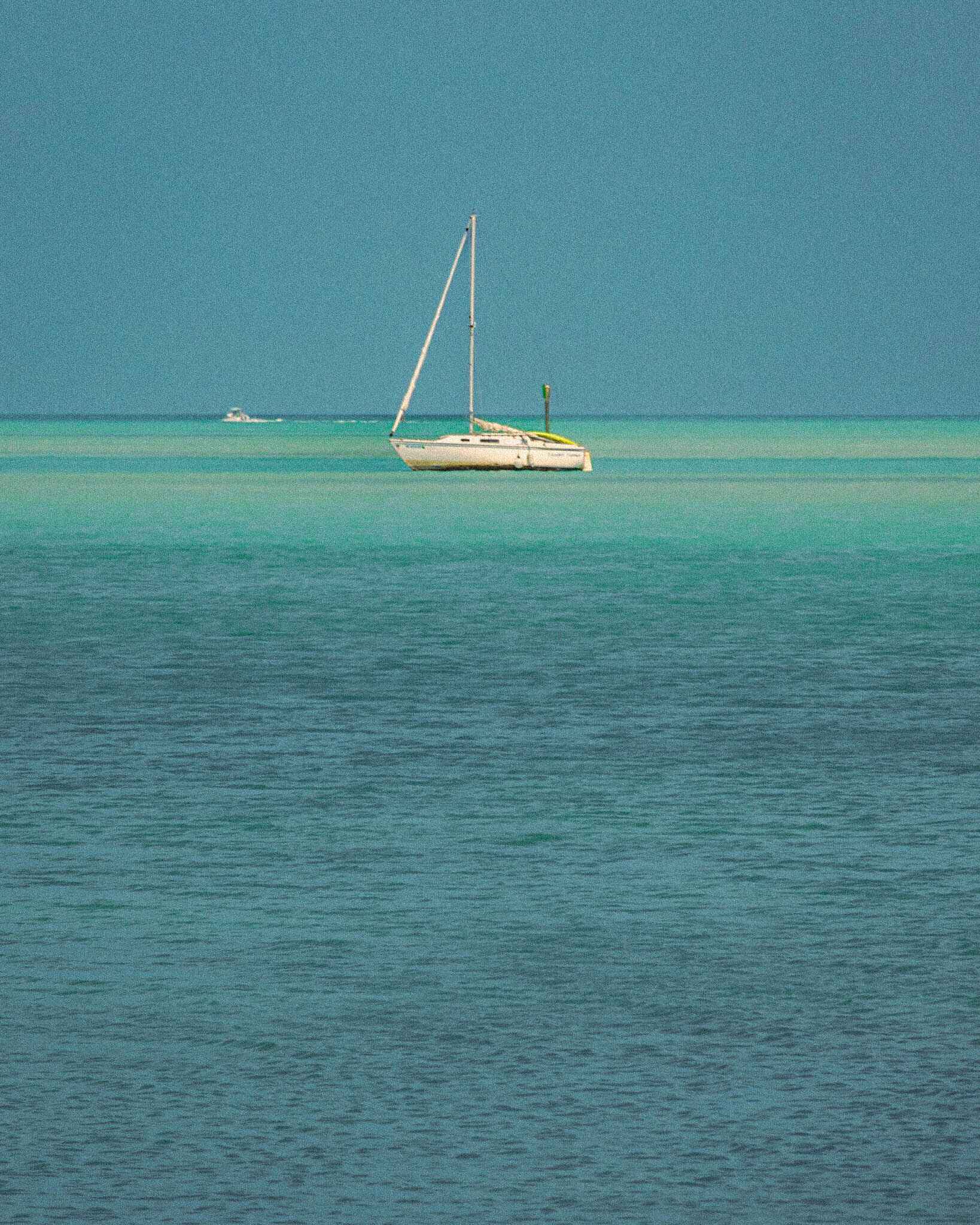 a sailboat in blue water in the florida keys