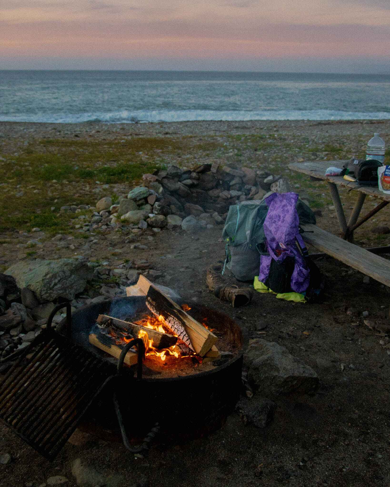 Two backpacks sit by a fire at parson's landing on Catalina Island