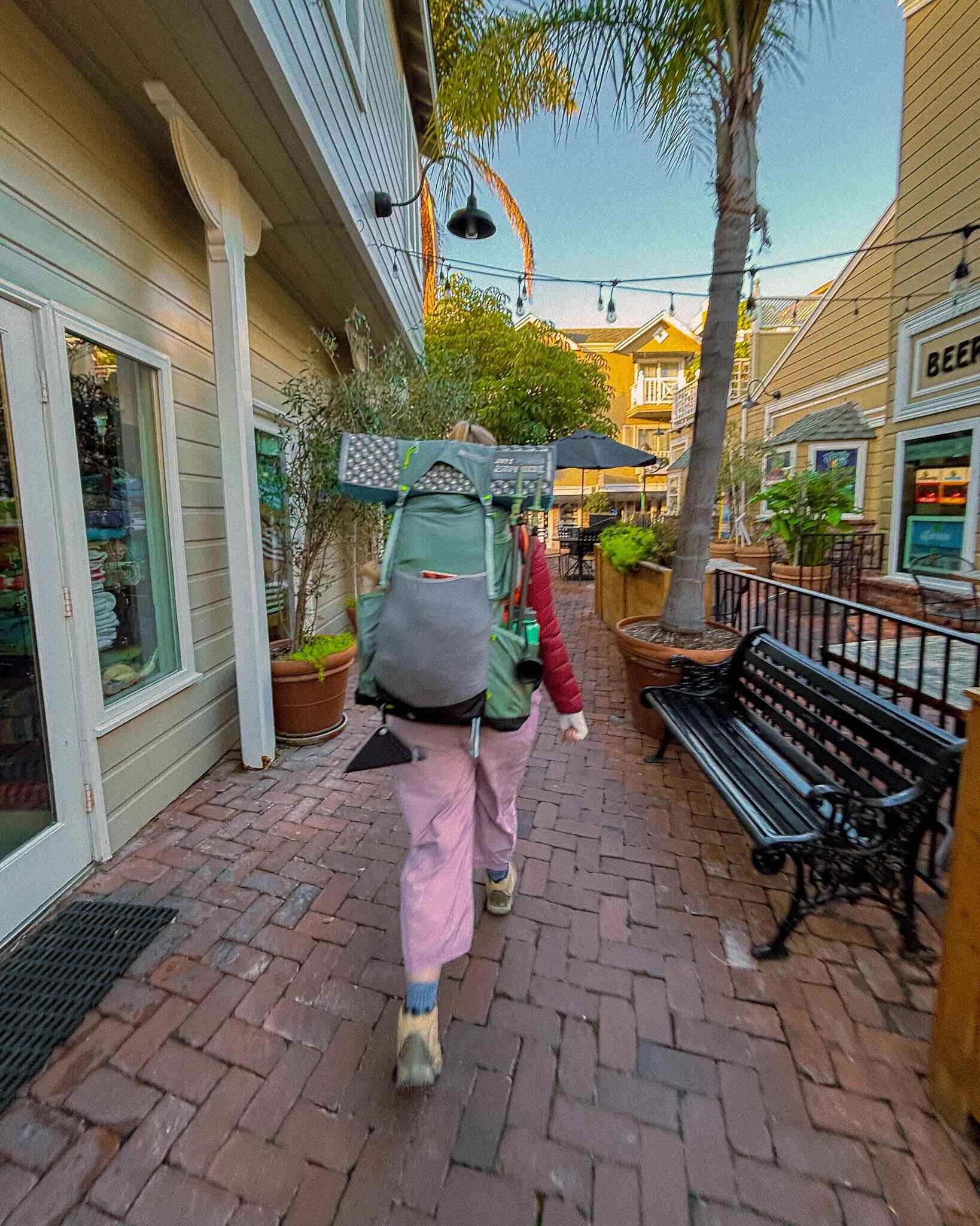 a backpacker walks through avalon at the start of the transcatalina trail