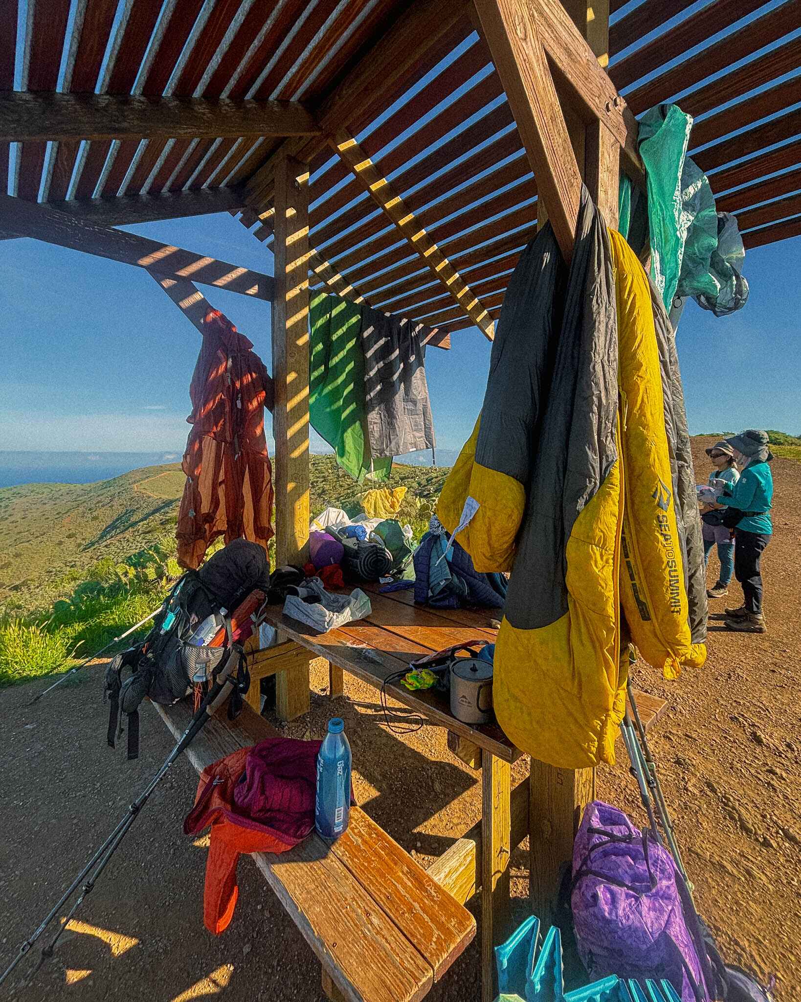 hikers dry out their gear at a pergola on the transcatalina trail