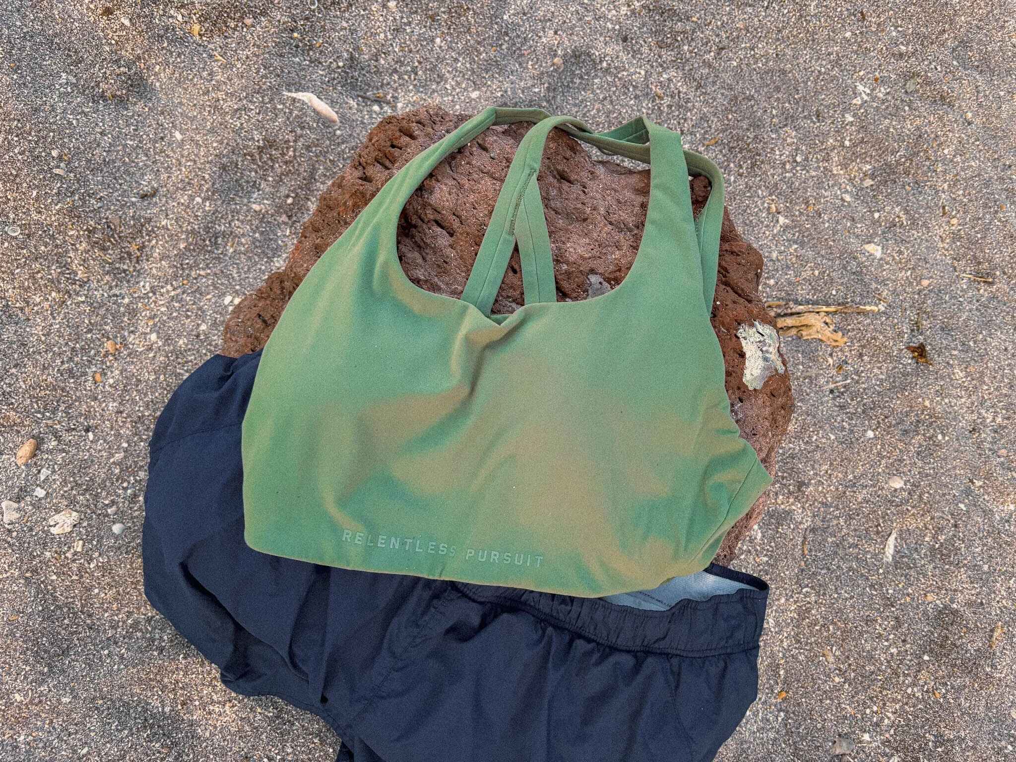 Close up of an ASRV Equinox sports bra on a rock on a beach
