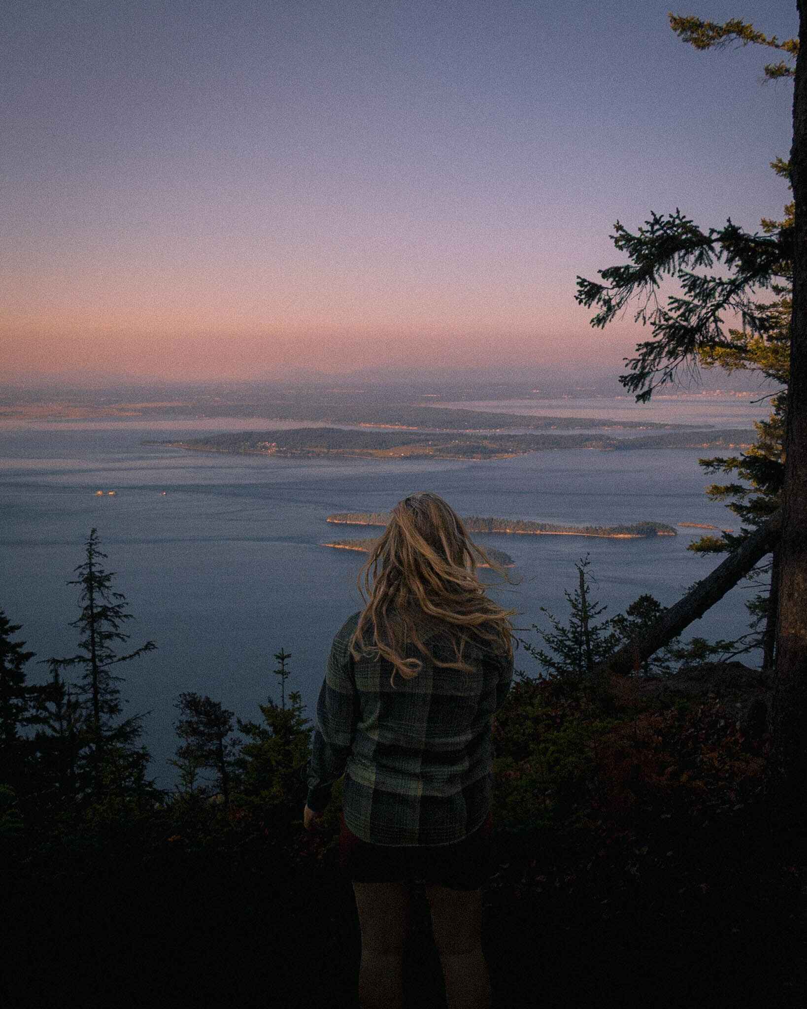 a hiker at an overlook in the san juan islands in belted style shorts