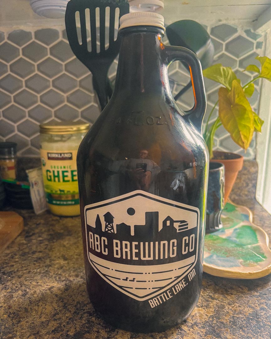 Image of an ABC brewing co growler sitting on a kitchen counter