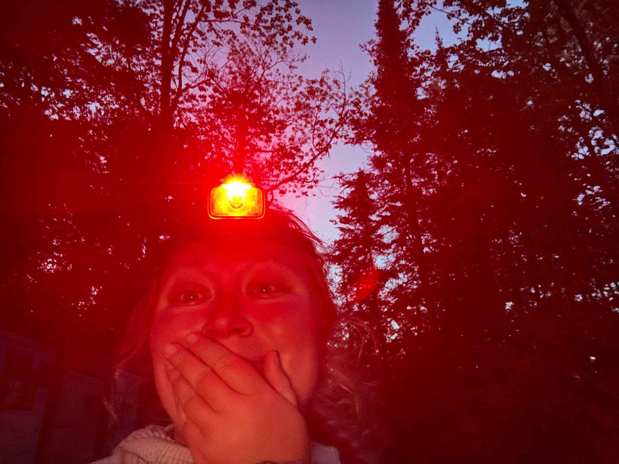 a woman wearing a red light headlamp