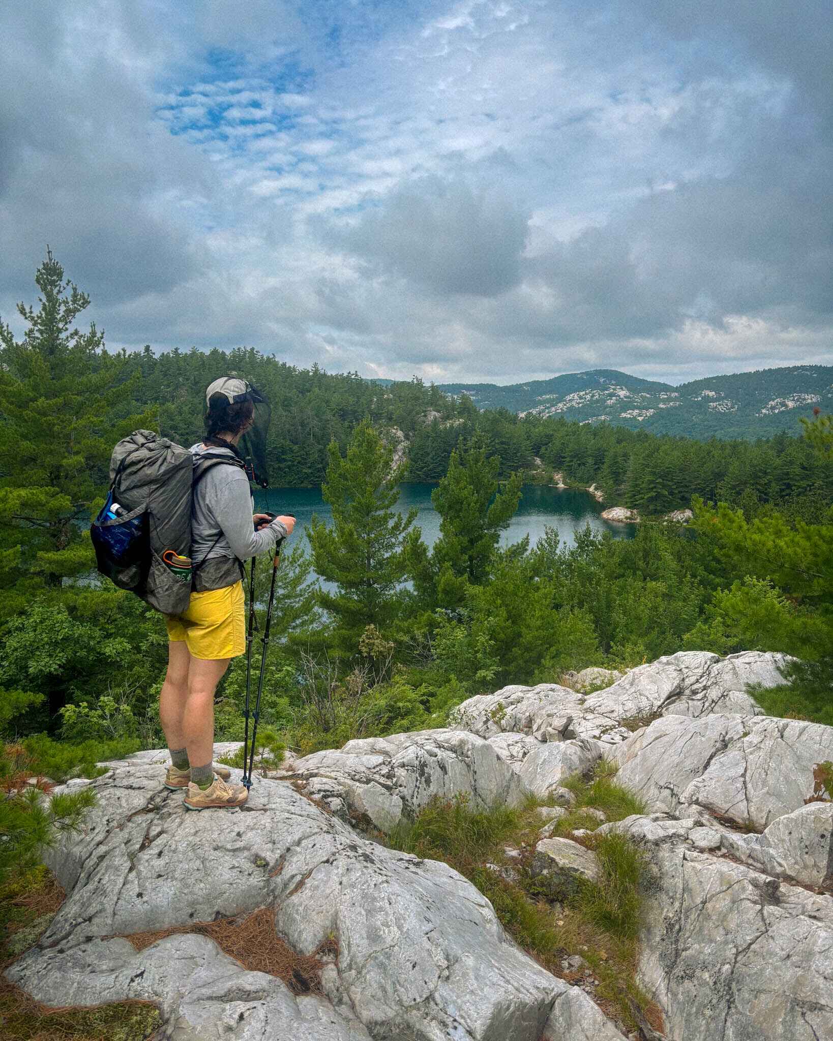 a backpacker wearing a bug net on. the La Cloche Silhouette Trail