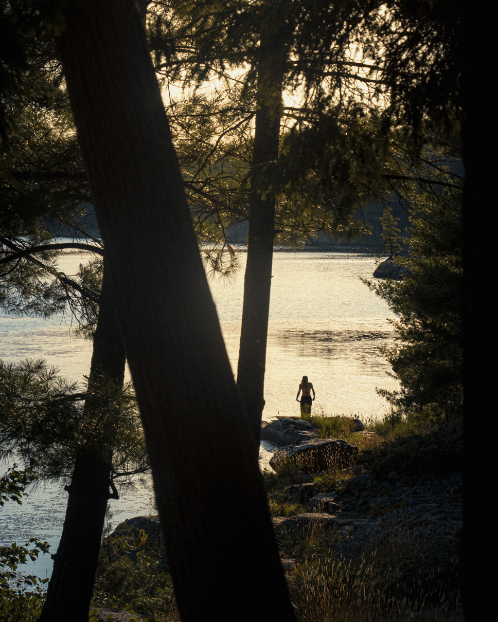 a hiker stands at the edge of Cave Lake