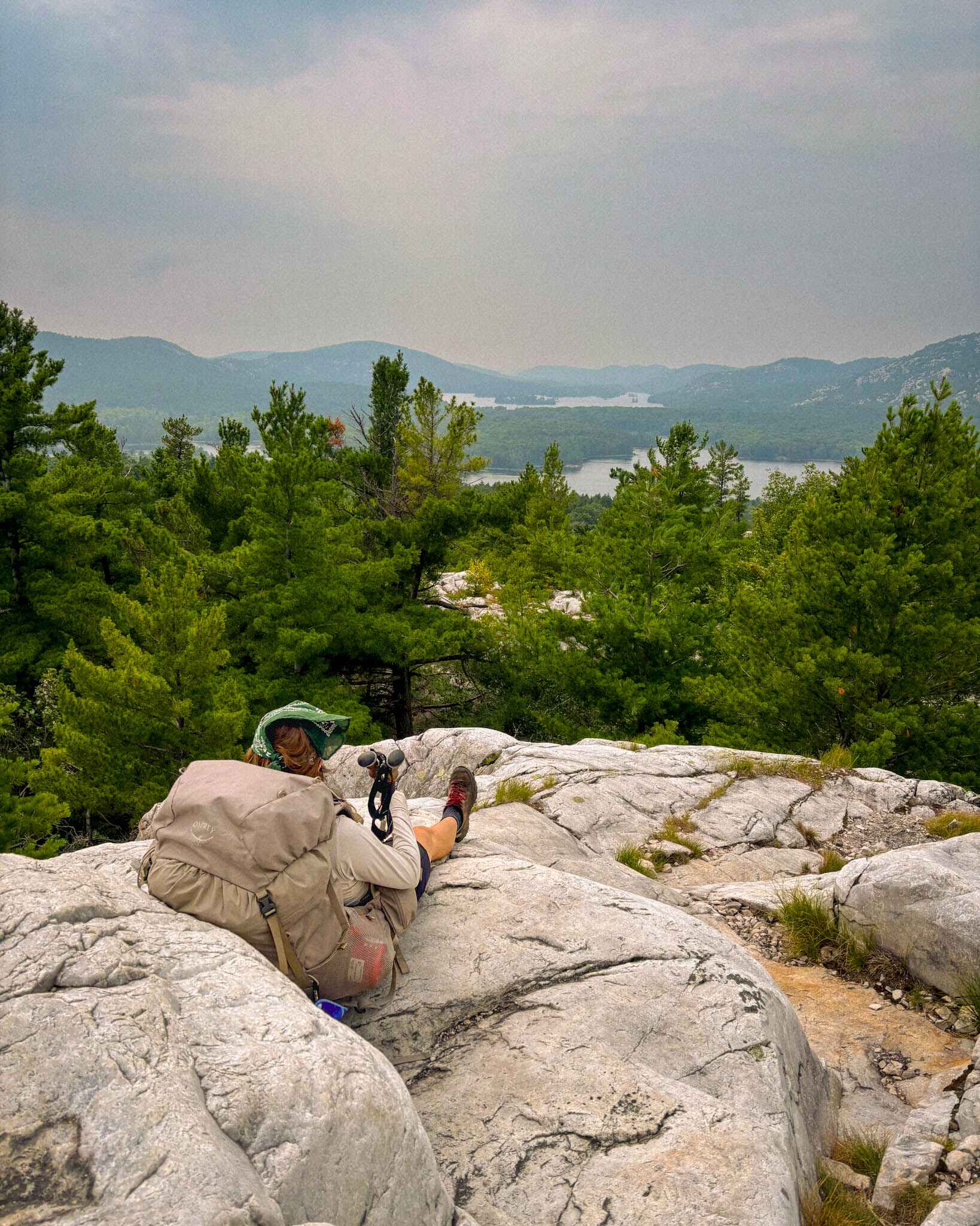 A thru hiker lounges at the top of the Crack in Killarney Provincial Park, Ontario