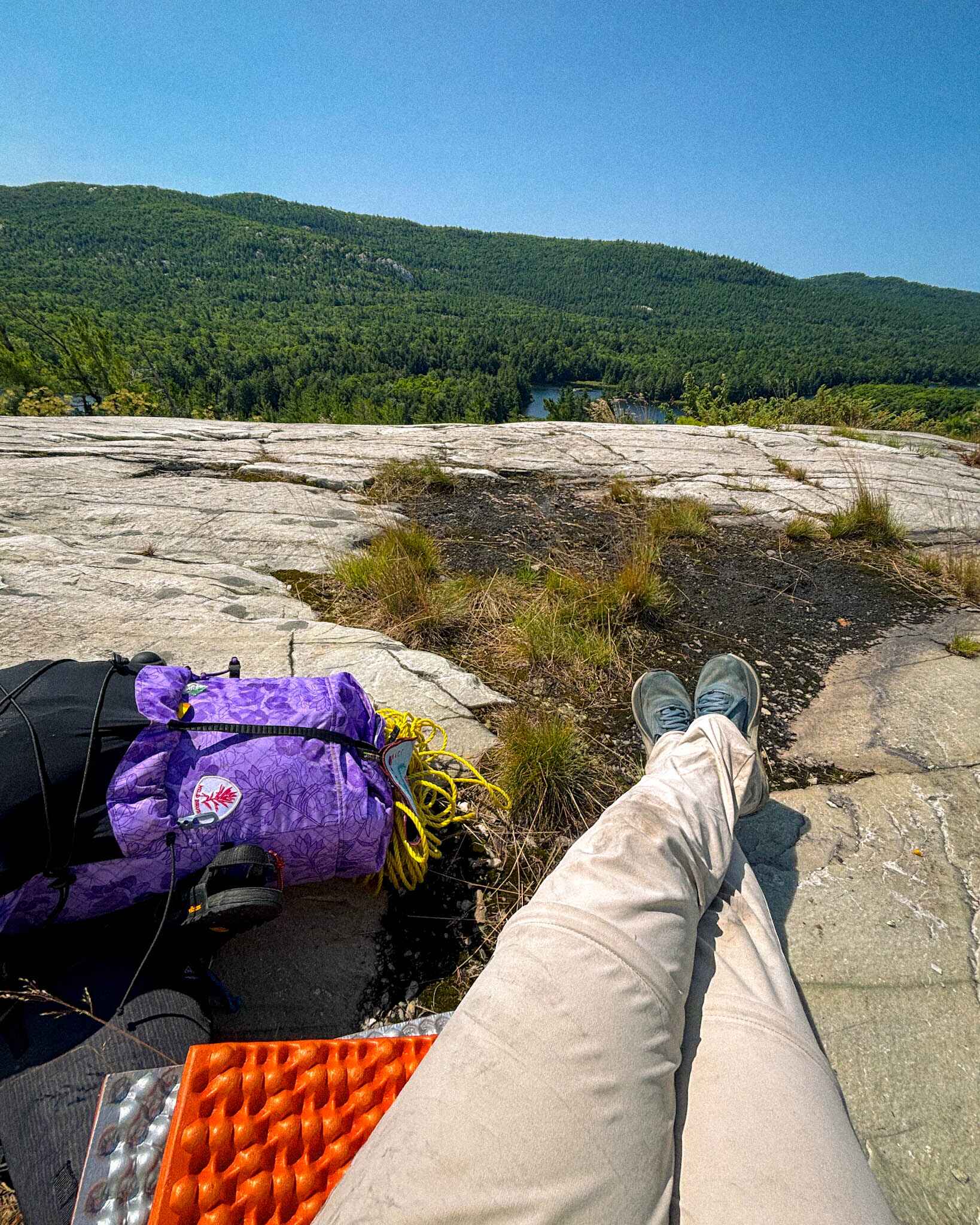Image of a hiker taking a break on a white quartsite ridge