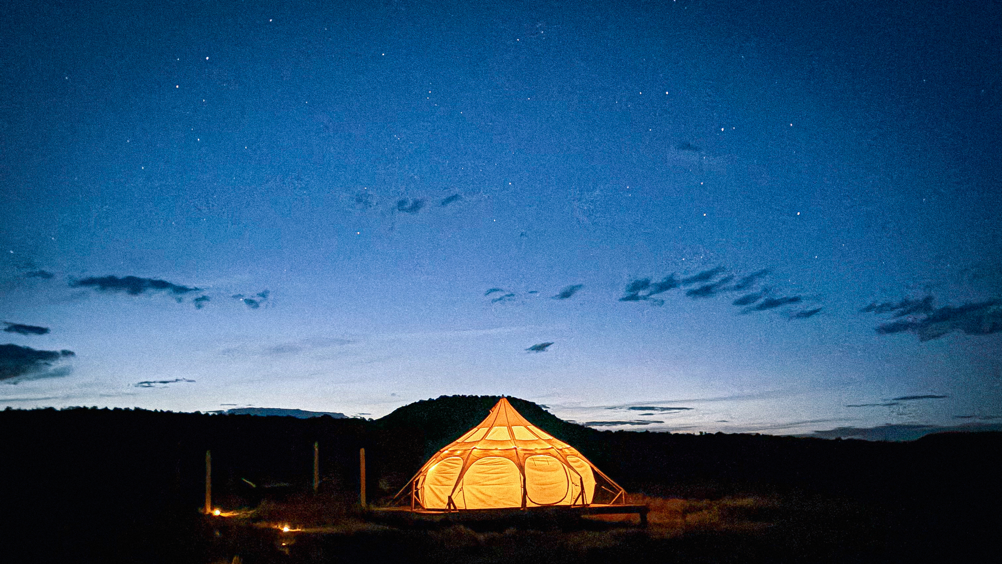 Image of a glamping tent near Moab lit against the night sky