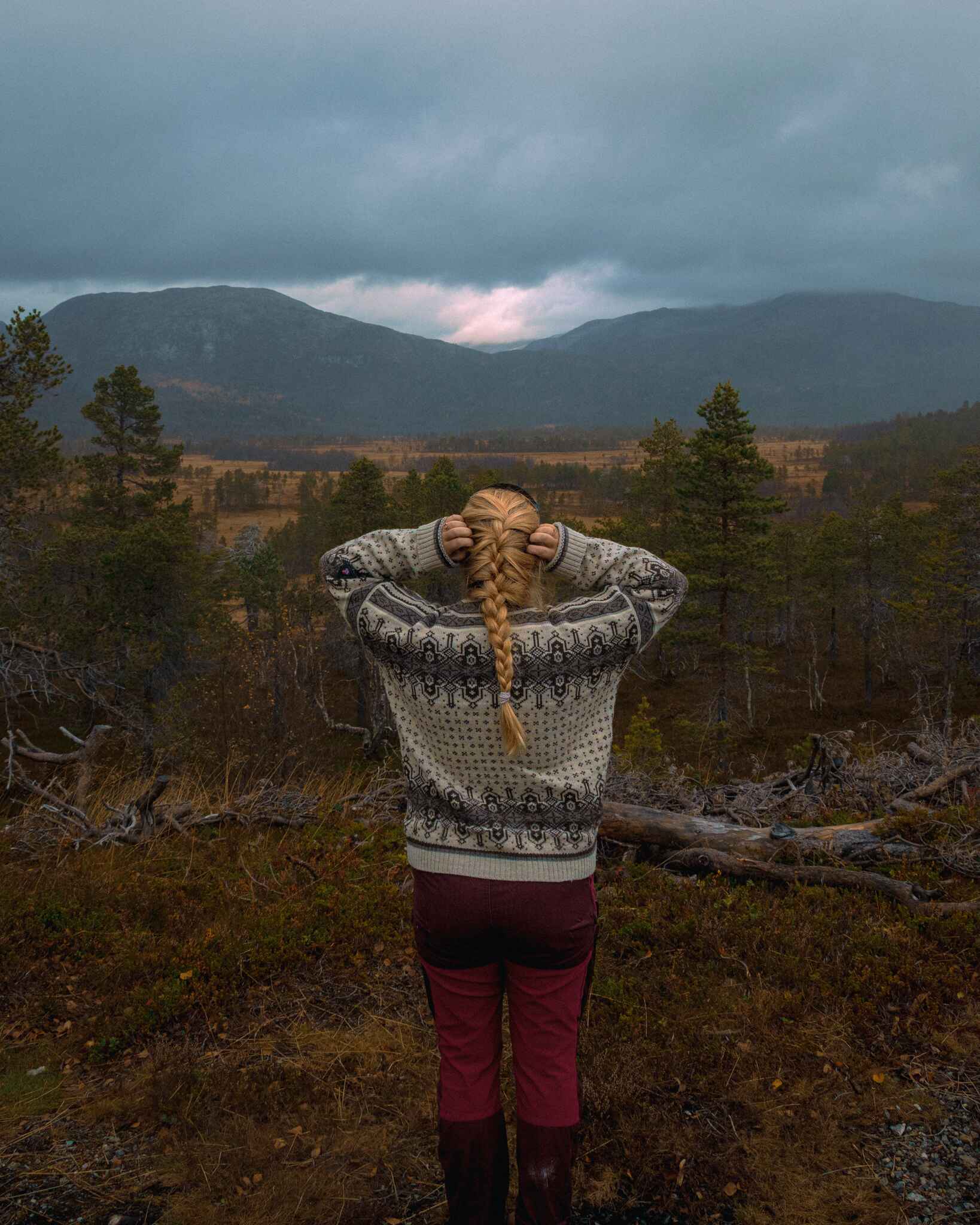 image of a hiker standing in front of rainy mountains on Senja Island, Norway