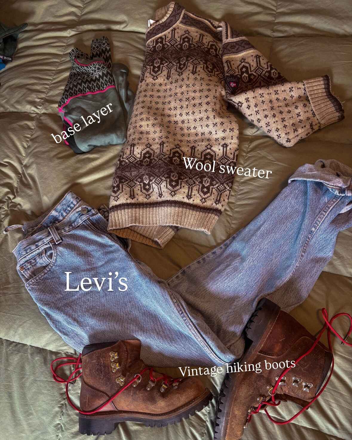 Flat lay of an outfit idea, labeled. Text reads: Base layer, wool sweater, Levi's, and vintage hiking boots