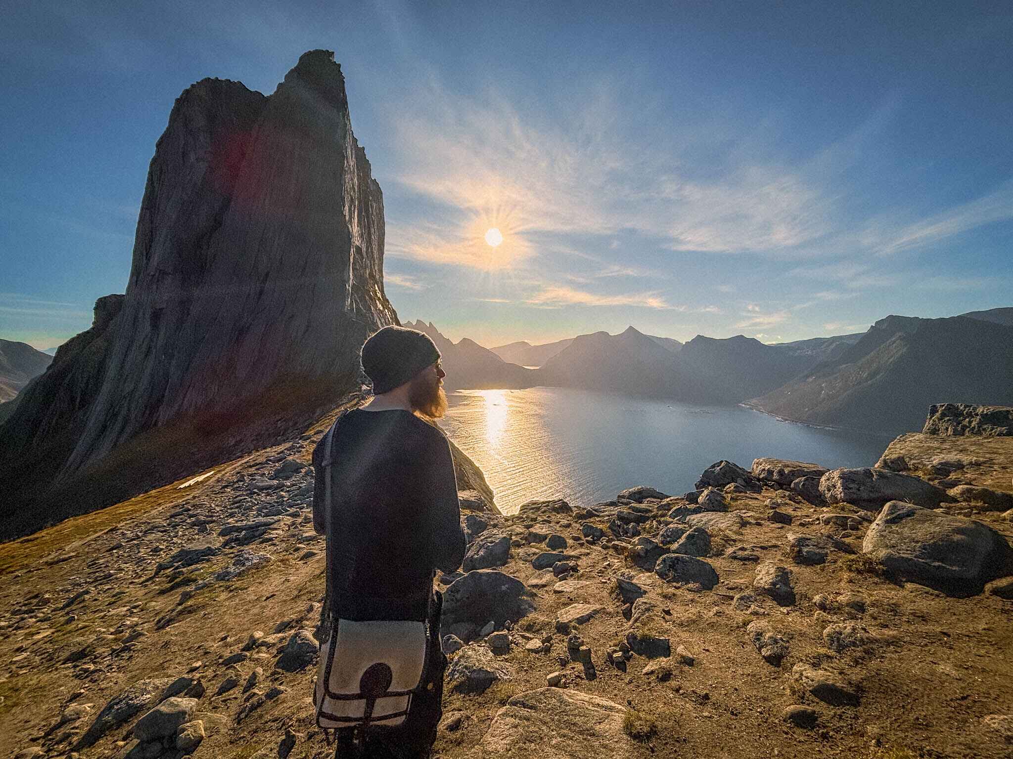 A hiker stands in front of Selga peak on Senja, Norway