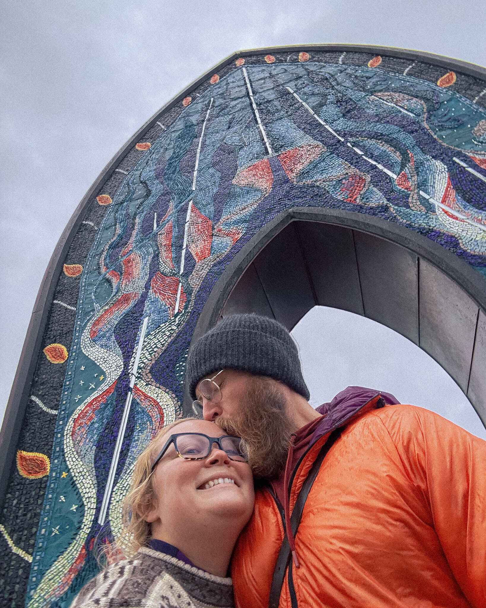 A couple in front fo Tromso's gateway to the arctic mosaic arch